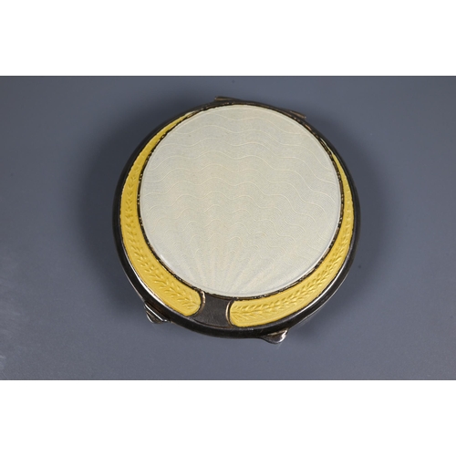 341 - An Art Deco silver and yellow enamel powder compact, Birmingham 1920, 7 cm diam; a locket silver and... 