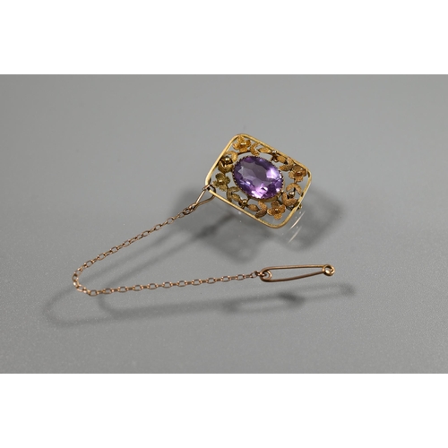 353 - A Victorian 9ct yellow gold brooch, the central oval amethyst surrounded by stylised flower and leaf... 