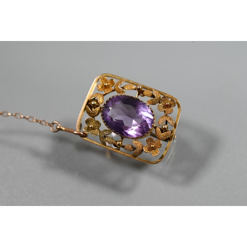 353 - A Victorian 9ct yellow gold brooch, the central oval amethyst surrounded by stylised flower and leaf... 