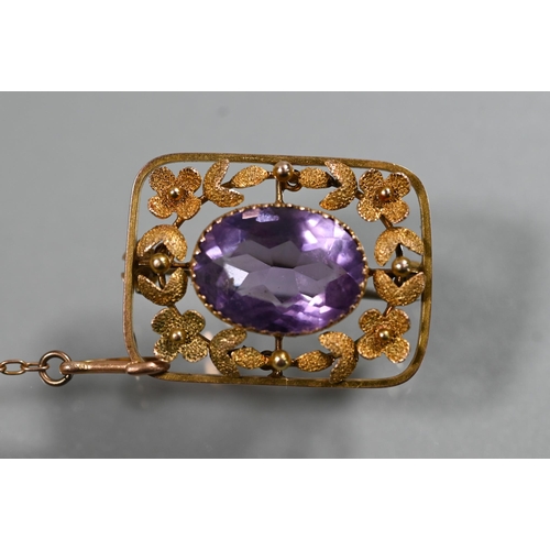 353 - A Victorian 9ct yellow gold brooch, the central oval amethyst surrounded by stylised flower and leaf... 