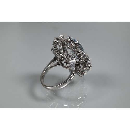 358 - A contemporary statement cluster ring, the oval claw set aquamarine surrounded by an arrangement of ... 