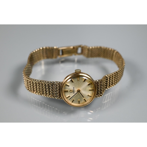 402 - An Omega 9ct gold ladies wristwatch, the champagne dial within a 18mm dia. case (20.4 g all-in) - in... 