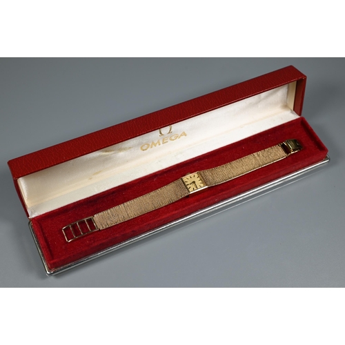 403 - An Omega 9ct gold ladies wristwatch, the 14 mm square case with gilt dial and textured strap (26 g a... 