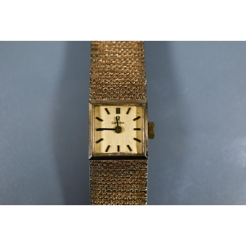 403 - An Omega 9ct gold ladies wristwatch, the 14 mm square case with gilt dial and textured strap (26 g a... 