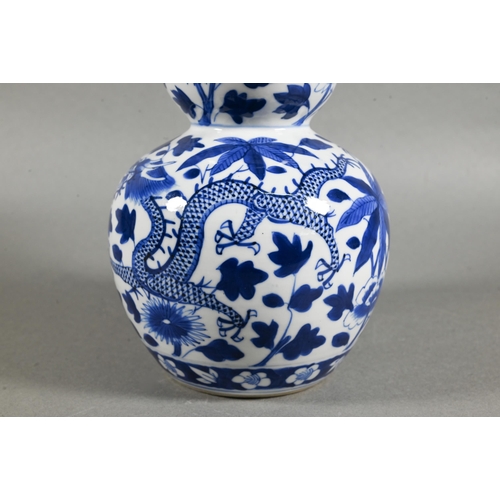 431 - A 19th/20th century Chinese blue and white double gourd vase painted with two sinuous dragons amongs... 