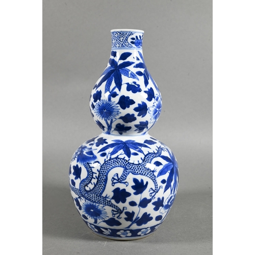 431 - A 19th/20th century Chinese blue and white double gourd vase painted with two sinuous dragons amongs... 