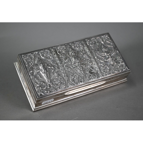 45 - A Siamese Sterling cigarette box, the hinged cover embossed and chased with deities, 21cm wide