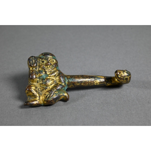 486 - A Chinese gilt bronze belt hook in the Han dynasty manner cast with a kneeling figure and serpents, ... 