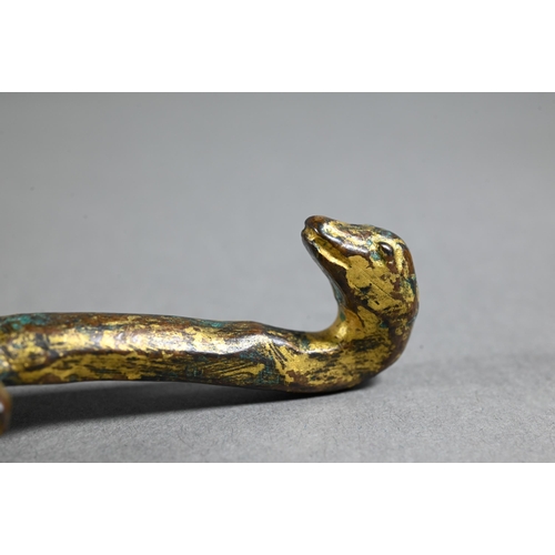 486 - A Chinese gilt bronze belt hook in the Han dynasty manner cast with a kneeling figure and serpents, ... 