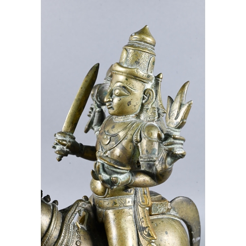 492 - An Indian brass figure of Khandoba (manifestation of Shiva) on the back of his horse, the four-armed... 