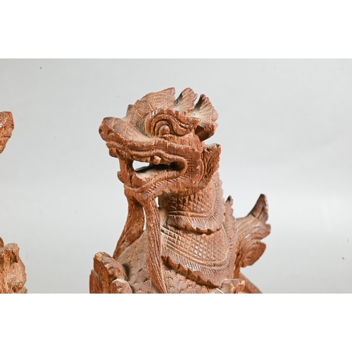 497 - A pair of South East Asian carved hardwood Buddhistic guardian lions, 15 cm high to/w a pair of knee... 