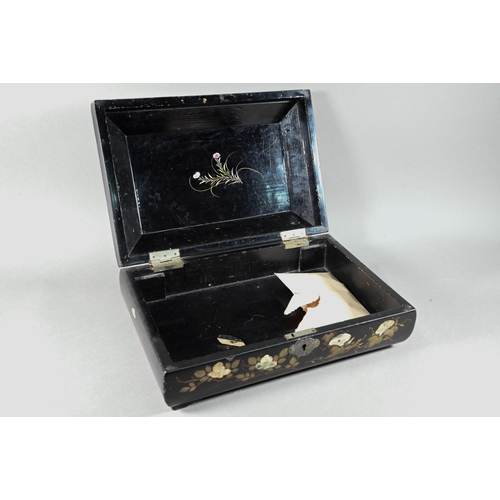 516 - An early 20th century Japanese black lacquered box with hinged cover decorated with birds and flower... 