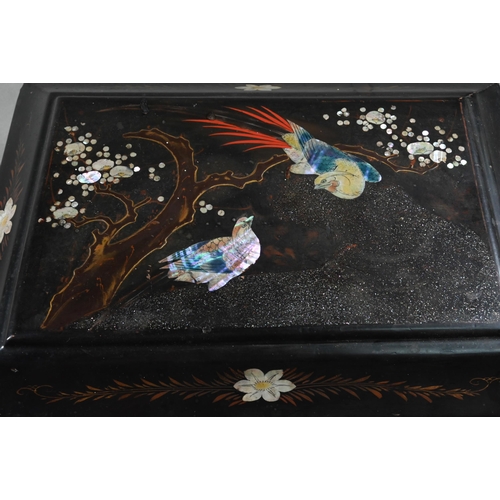 516 - An early 20th century Japanese black lacquered box with hinged cover decorated with birds and flower... 