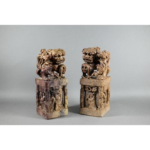 523 - A pair of Chinese carved soapstone block seals, surmounted by Kylin, 21 cm