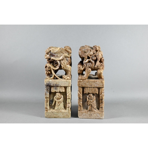 523 - A pair of Chinese carved soapstone block seals, surmounted by Kylin, 21 cm