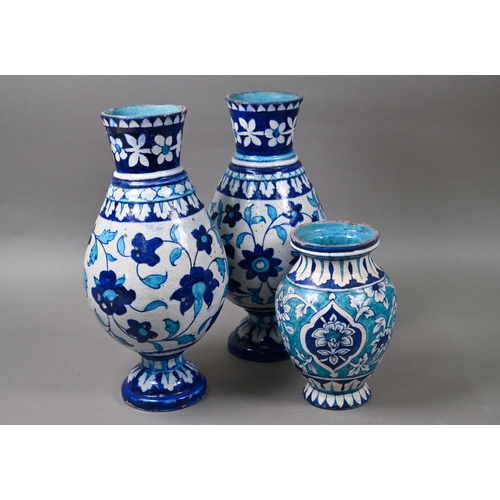 579 - A pair of antique Isnic ovoid vases with tapered neck and stemmed bases, painted with blue and white... 