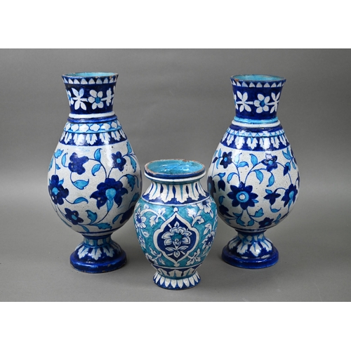 579 - A pair of antique Isnic ovoid vases with tapered neck and stemmed bases, painted with blue and white... 