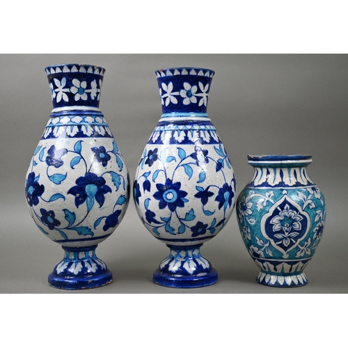 579 - A pair of antique Isnic ovoid vases with tapered neck and stemmed bases, painted with blue and white... 