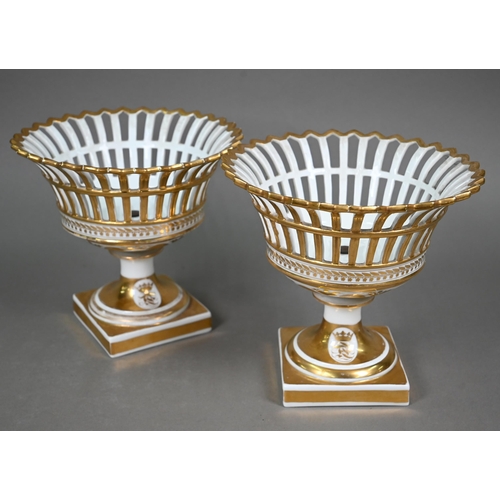 603 - A pair of Continental porcelain pierced baskets with flared tops and stemmed square bases, decorated... 