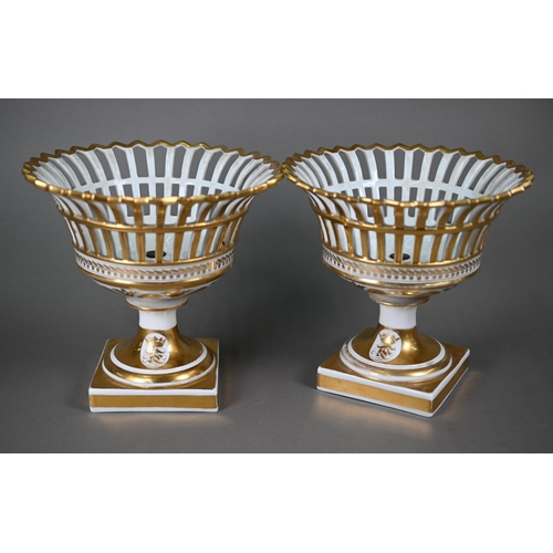 603 - A pair of Continental porcelain pierced baskets with flared tops and stemmed square bases, decorated... 