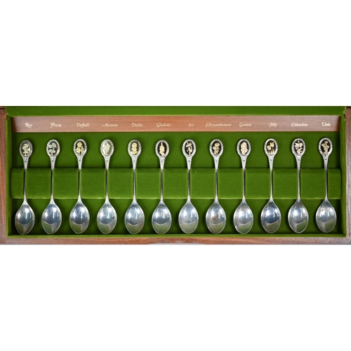 66 - A teak-cased set of twelve Royal Horticultural society Flower Spoons, the finials with inset gilt me... 