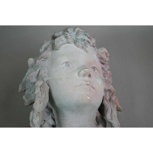 75 - An Art Nouveau head and shoulder ceramic bust of a young girl, modelled with cap and ringlets, later... 