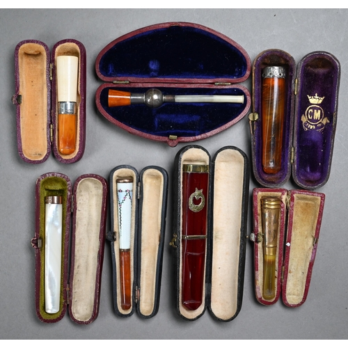 1068 - A selection of twelve cased cheroot/cigarette-holders, variously in amber, meerschaum, silver, ename... 