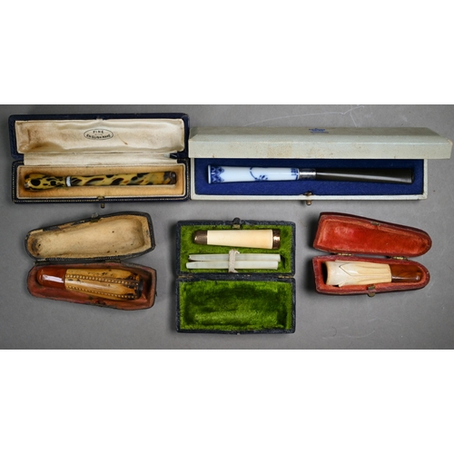 1068 - A selection of twelve cased cheroot/cigarette-holders, variously in amber, meerschaum, silver, ename... 