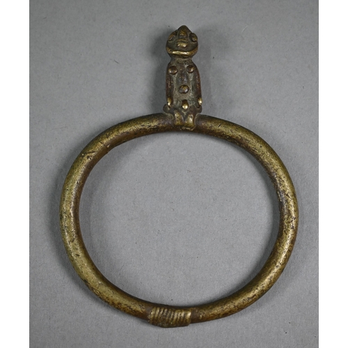 1075 - A West African bronze bangle, surmounted by a seated man, 11.5 x 9 cm