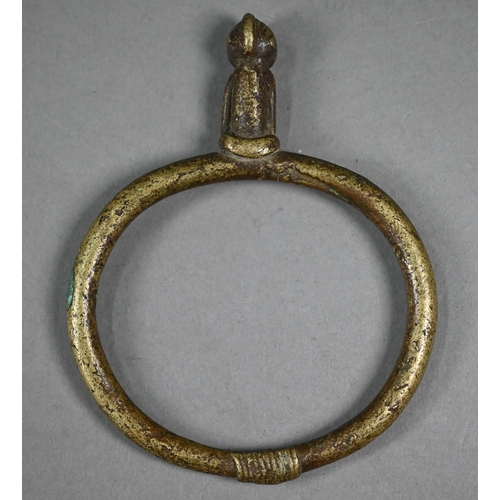 1075 - A West African bronze bangle, surmounted by a seated man, 11.5 x 9 cm