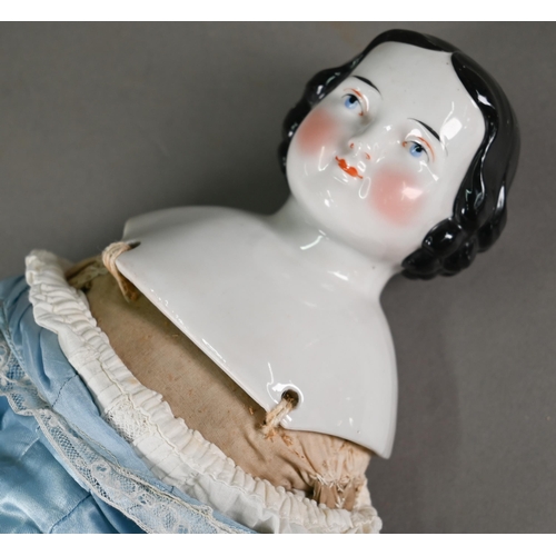 1158 - A Victorian china-headed girl doll, on stuffed fabric body with china lower limbs (one leg restored)... 