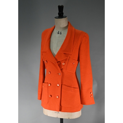 1187 - A Chanel Boutique fitted long-line jacket in orange boucle wool, double breasted with four pockets a... 