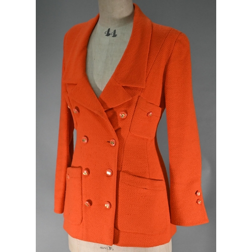 1187 - A Chanel Boutique fitted long-line jacket in orange boucle wool, double breasted with four pockets a... 