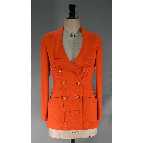 1187 - A Chanel Boutique fitted long-line jacket in orange boucle wool, double breasted with four pockets a... 