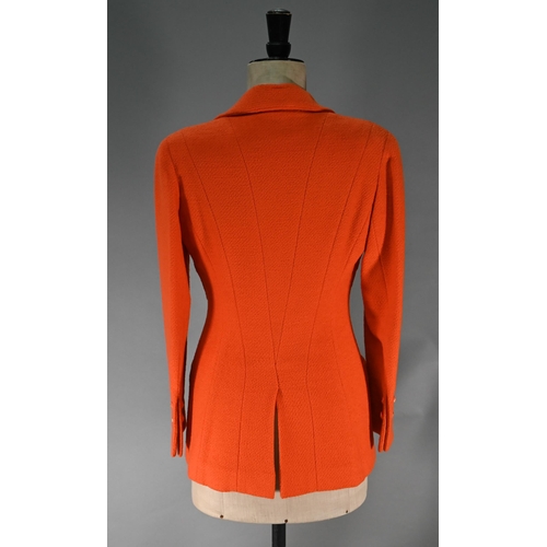 1187 - A Chanel Boutique fitted long-line jacket in orange boucle wool, double breasted with four pockets a... 