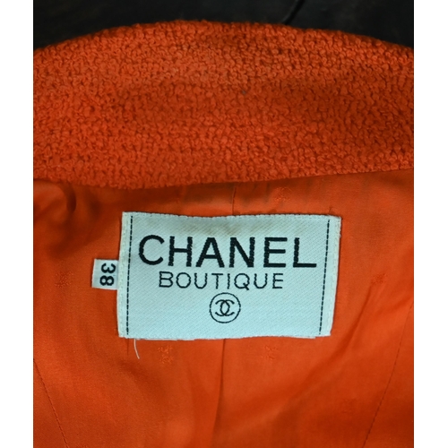 1187 - A Chanel Boutique fitted long-line jacket in orange boucle wool, double breasted with four pockets a... 