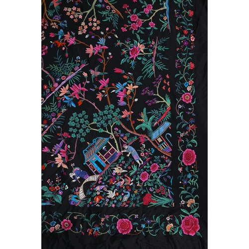 1203 - A Chinese black silk fringed piano shawl, abundantly embroidered with Pagoda scenes, figures and exo... 