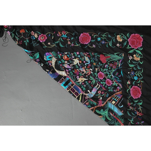 1203 - A Chinese black silk fringed piano shawl, abundantly embroidered with Pagoda scenes, figures and exo... 