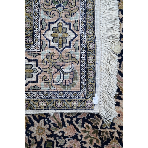 803 - An old silk Hereke rug, the field of repeating geometric flower heads on dark blue ground, 157 cm x ... 