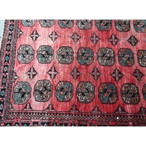 807 - An old North East Persian Turkoman rug, the red ground with three rows of stylised guls, 252 cm x 16... 