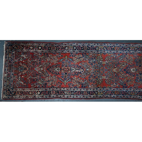 809 - An old Persian Sarouk runner, the stylised floral vine design on pale red ground, 358 cm x 107 cmPro... 