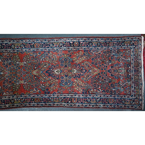 809 - An old Persian Sarouk runner, the stylised floral vine design on pale red ground, 358 cm x 107 cmPro... 