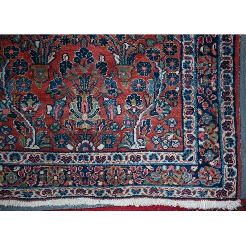 809 - An old Persian Sarouk runner, the stylised floral vine design on pale red ground, 358 cm x 107 cmPro... 