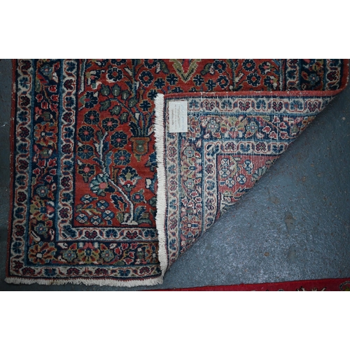 809 - An old Persian Sarouk runner, the stylised floral vine design on pale red ground, 358 cm x 107 cmPro... 