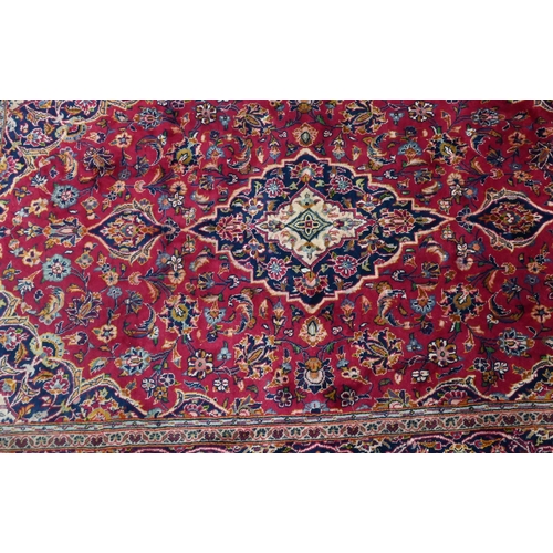 810 - An old Persian Kashan rug, the red ground centred by a floral medallion, 215 cm x 135 cm