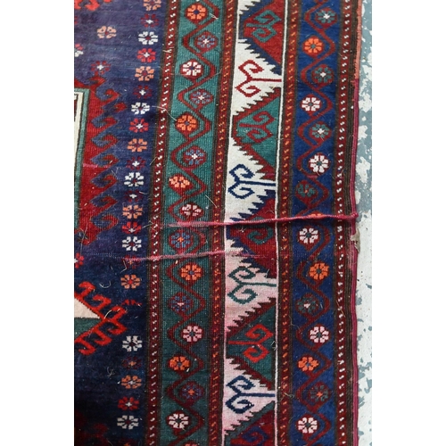 811 - An old Caucasian kelleh carpet, the blue ground with multi-coloured lozenge design, 326 cm x 178 cm