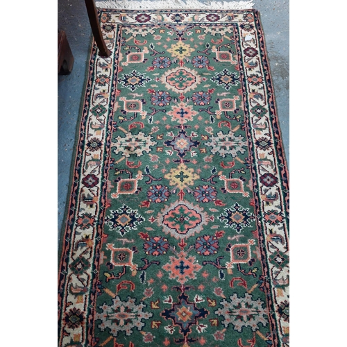 815 - An old Persian green ground runner, 292 cm x 76 cm