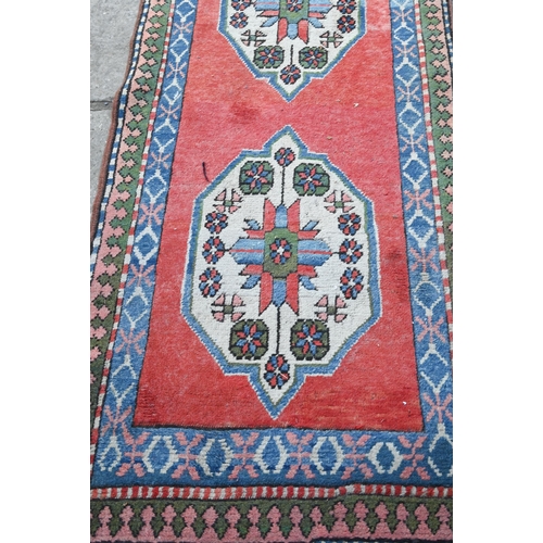 817 - A Turkish Kazak design runner, the four diamond pole design on red ground, 323 cm x 78 cm