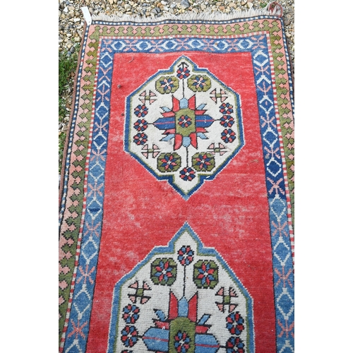 817 - A Turkish Kazak design runner, the four diamond pole design on red ground, 323 cm x 78 cm