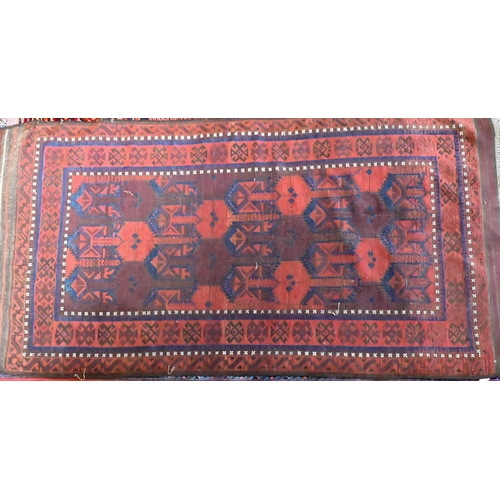 822 - An antique Belouch rug, the red-brown ground with narrow blue bands and wide kelim ends, 202 cm x 10... 